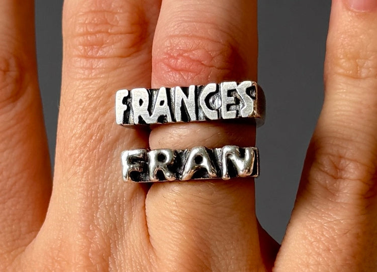 Silver signet rings in flat and bubble letters.