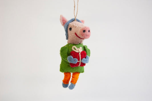 Felted pig ornament wearing a green sweater and blue hat, holding a red gift box on a white background - ZWEIBIE